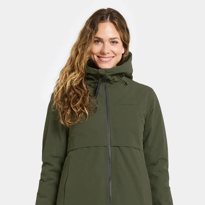 Woman with long wavy brown hair in dark green Didriksons Helle Womens Parka for outdoors