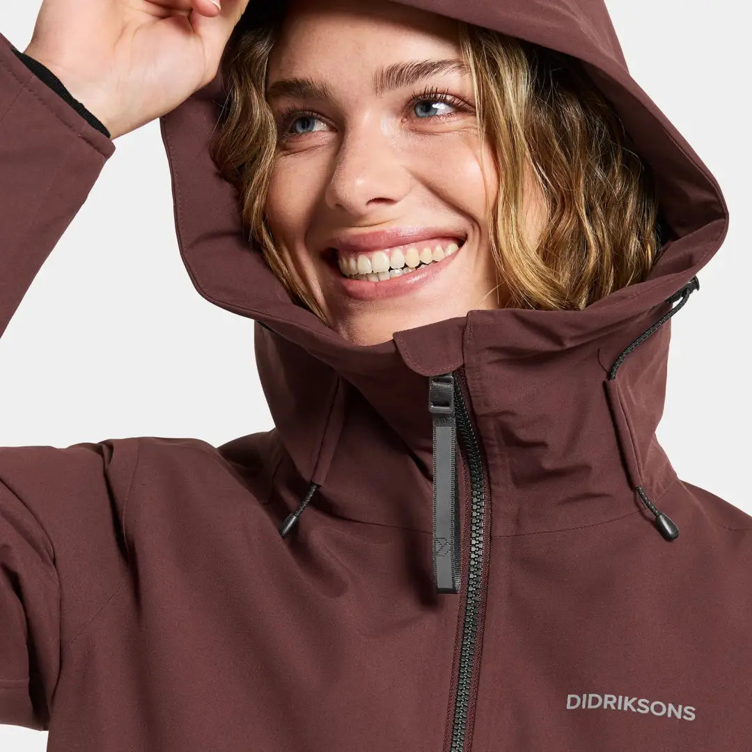 Smiling woman in maroon Didriksons Helle Womens Parka, perfect for country clothing outdoors