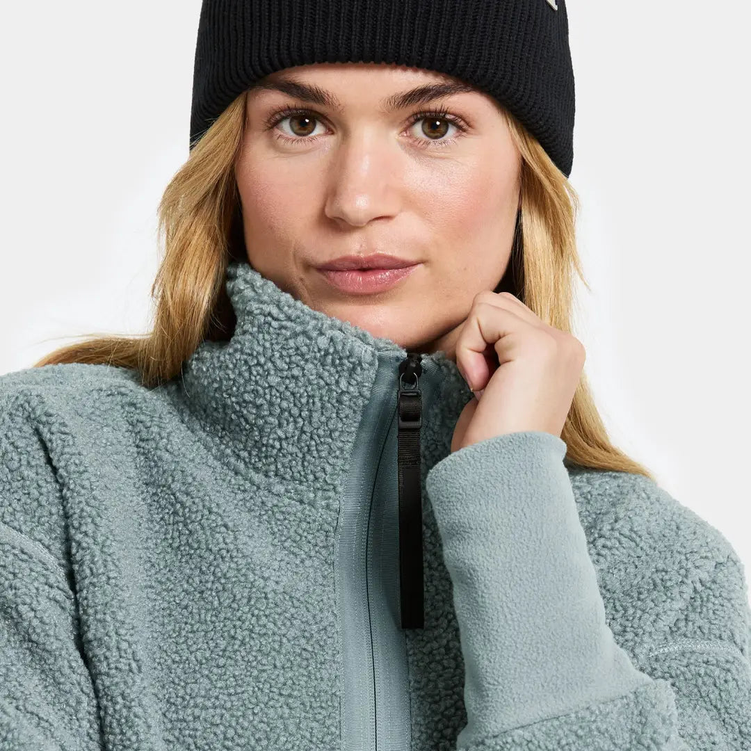 Woman in black beanie and teal fleece jacket from Didriksons Mella 3 for country clothing outdoors