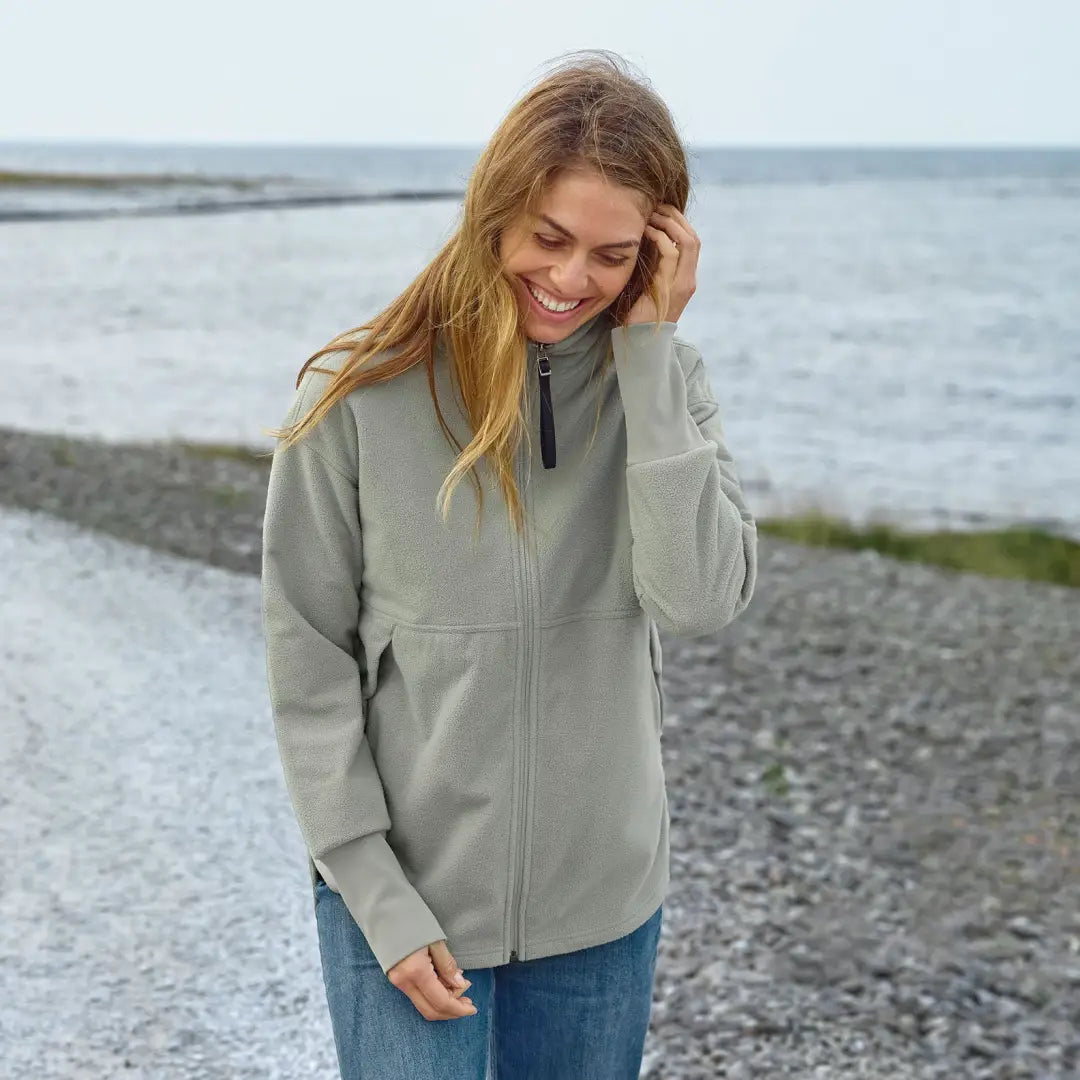 Woman in Didriksons Ronja fleece jacket by the sea, perfect for country clothing outdoors