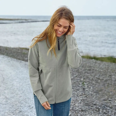Woman in Didriksons Ronja fleece jacket by the sea, perfect for country clothing outdoors