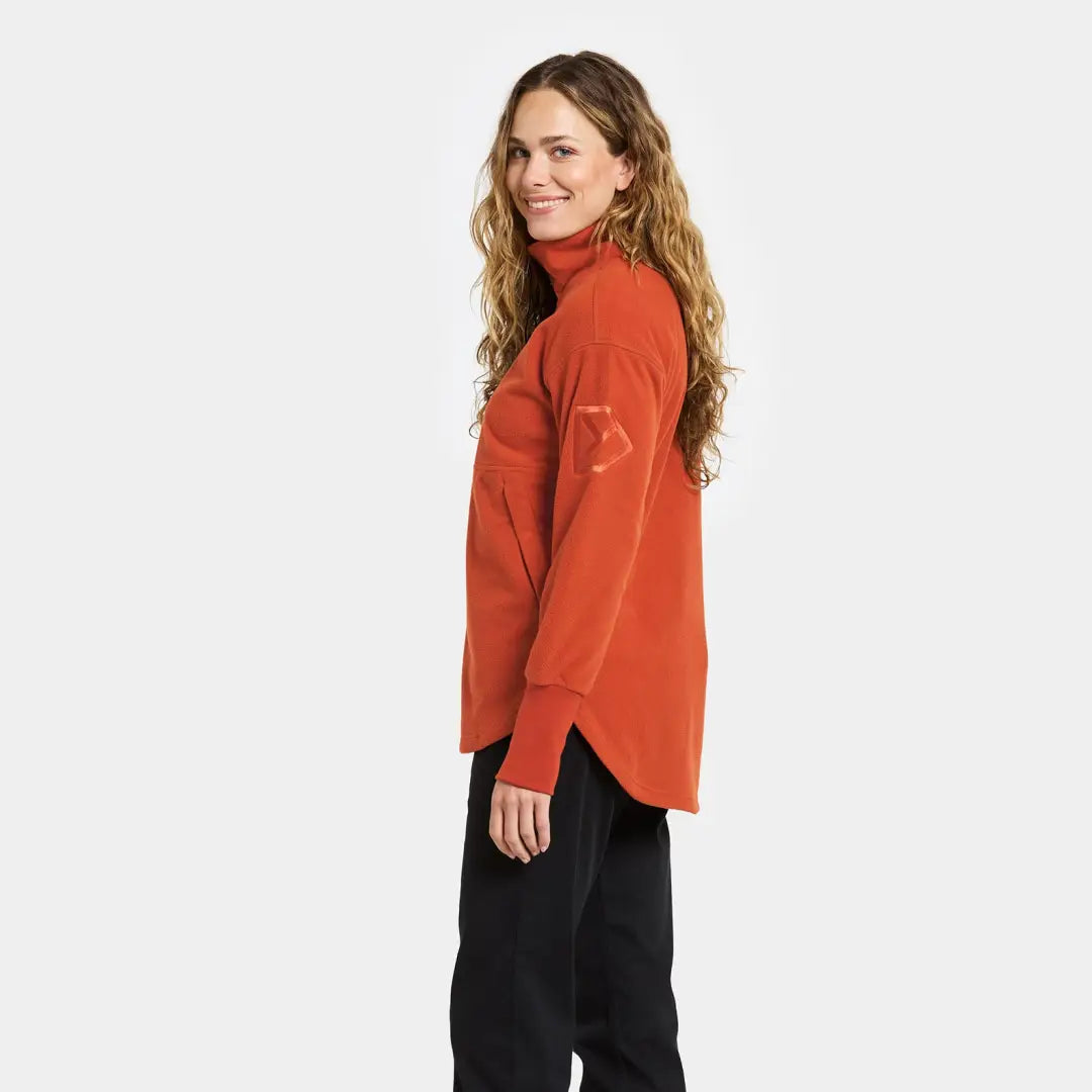 Woman in orange turtleneck and black pants wearing Didriksons Ronja fleece for outdoor country clothing