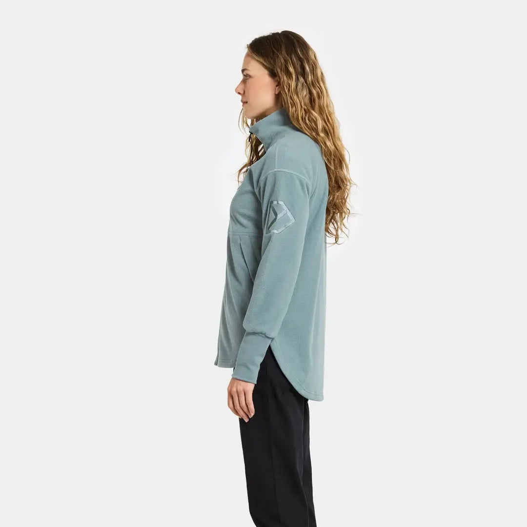 Woman in light blue fleece top and black pants, perfect for country clothing outdoors