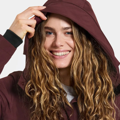 Smiling woman in burgundy Didriksons Selina Womens Parka, perfect for outdoors and country clothing