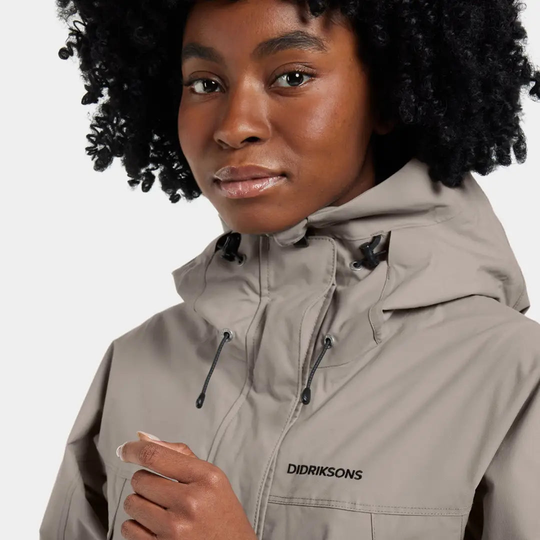 Woman in light brown hooded jacket showcasing iconic Didriksons style fully waterproof windproof parka