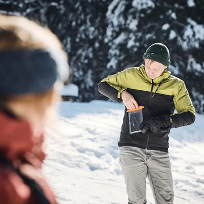 Man in winter gear holding Fidlock Medi Dry Bag waterproof phone case