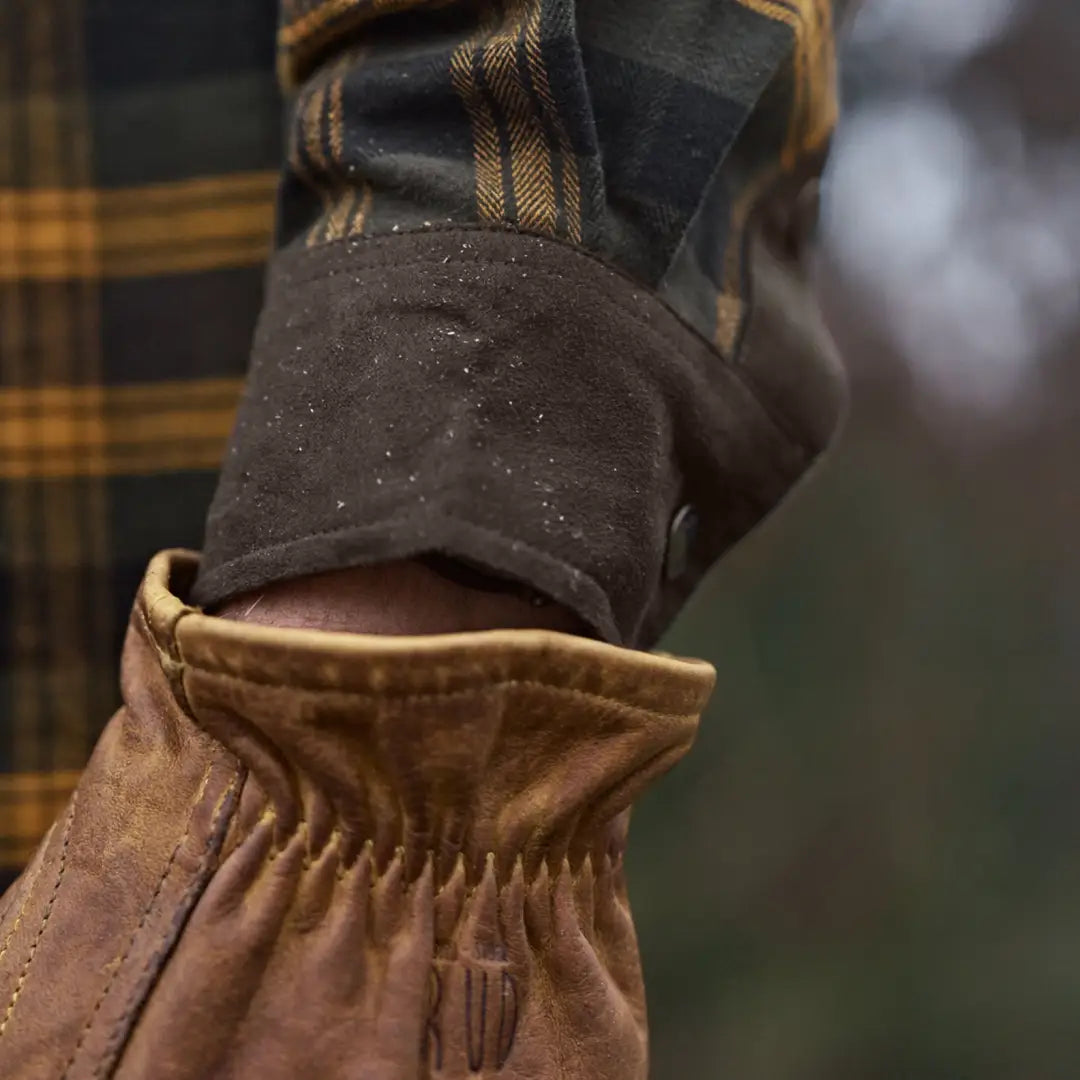Leather-gloved hand with plaid sleeve showcasing Härkila Aivak Long Sleeve Shirt for hunting
