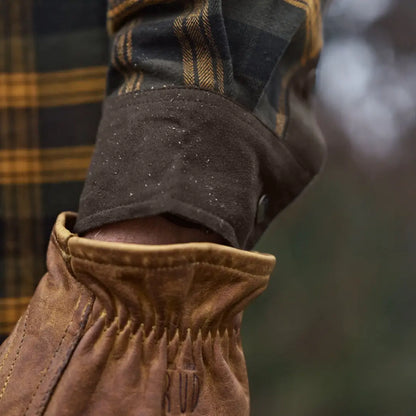 Leather-gloved hand with plaid sleeve showcasing Härkila Aivak Long Sleeve Shirt for hunting