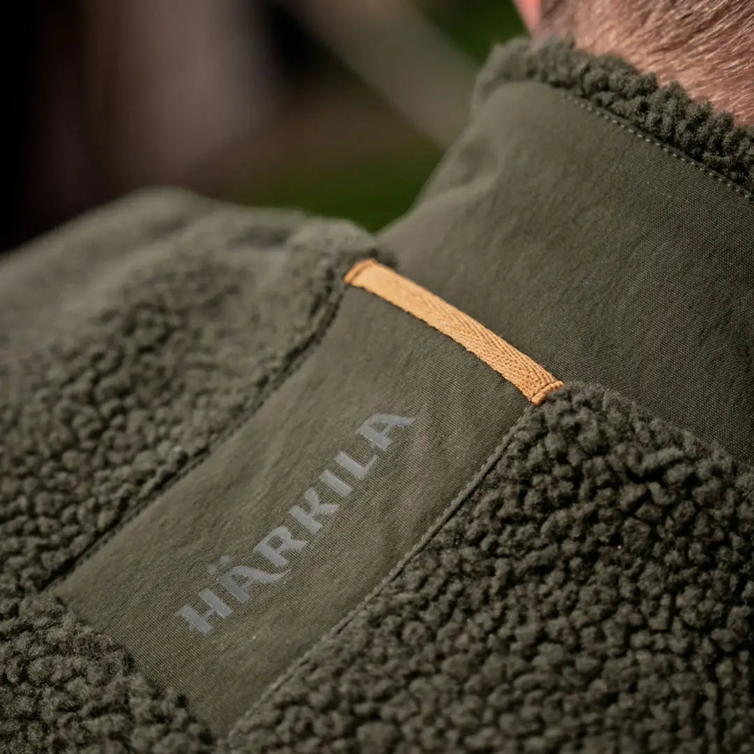 Green fleece jacket with logo for Härkila Fjell Polar Waistcoat, perfect for outdoor adventures