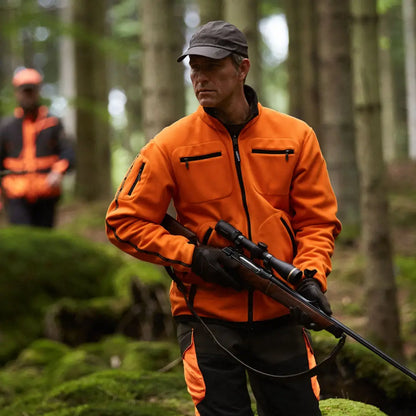 Hunter in a Härkila Kamko reversible fleece jacket holding a rifle for hunting in country clothing
