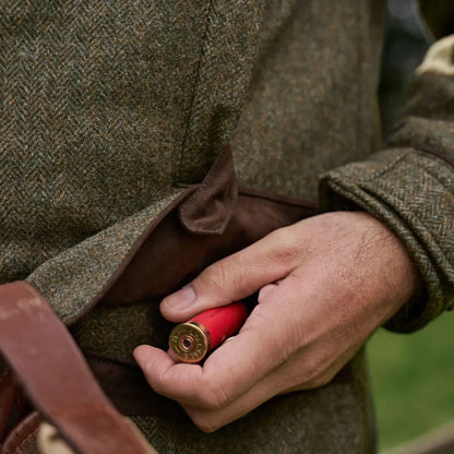 Red shotgun shell displayed with Harkila Kenmore GTX Jacket for outdoor gear enthusiasts