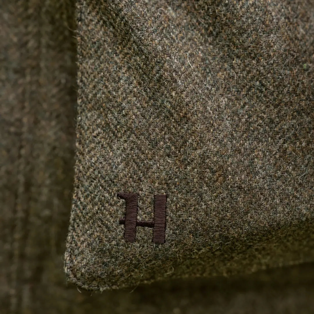 Green herringbone fabric with embroidered H on Kenmore GTX Jacket for style and durability