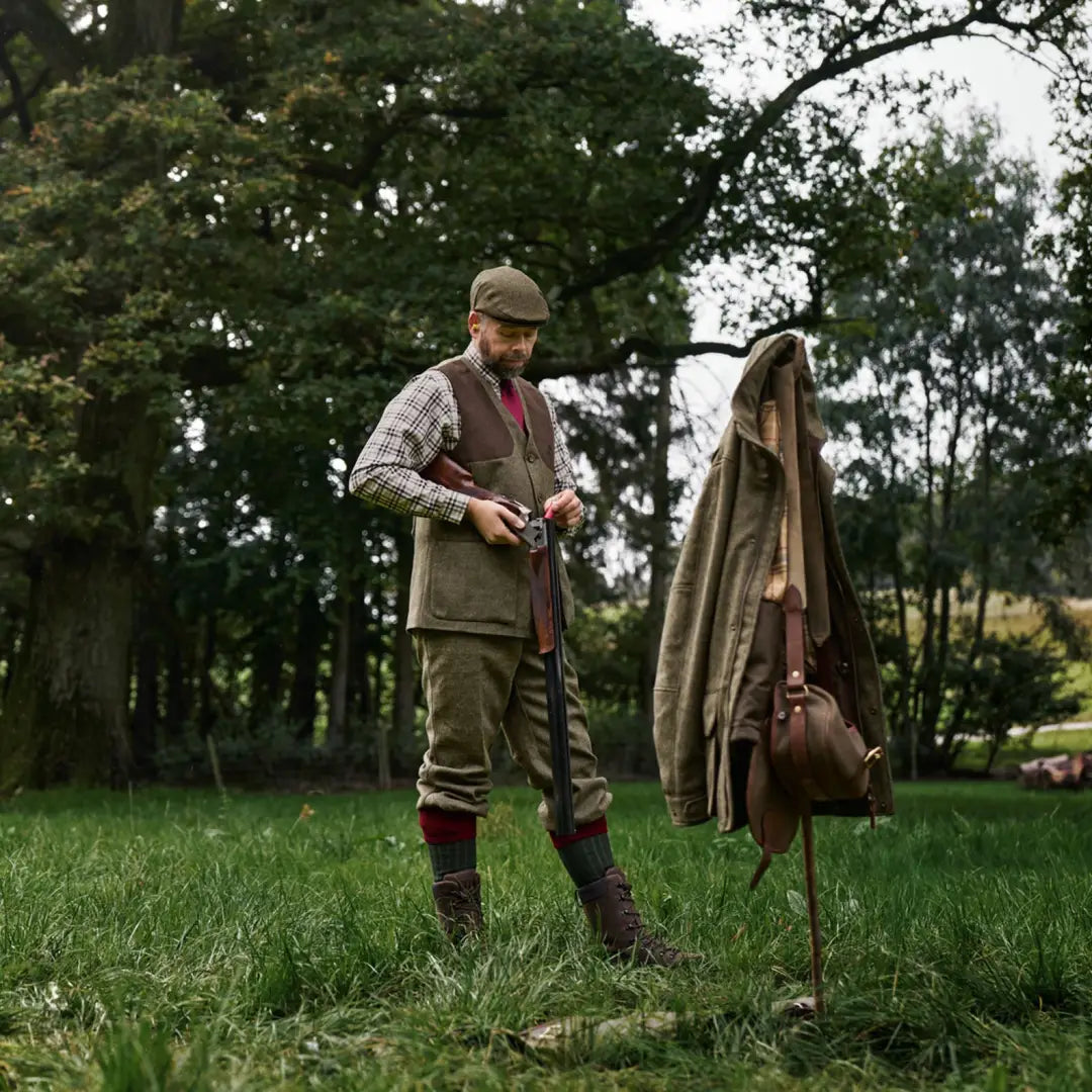 Hunter in tweed wearing the Harkila Kenmore Shooting Waistcoat for a classic shooting look