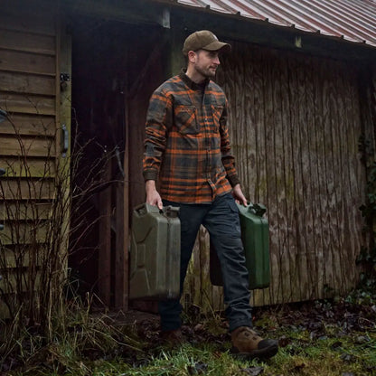 Man carrying two green jerrycans wearing Harkila Pajala Shirt with press button closure