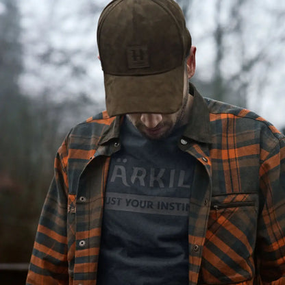 Man in plaid shirt and cap wearing Harkila Pajala Shirt with press button closure