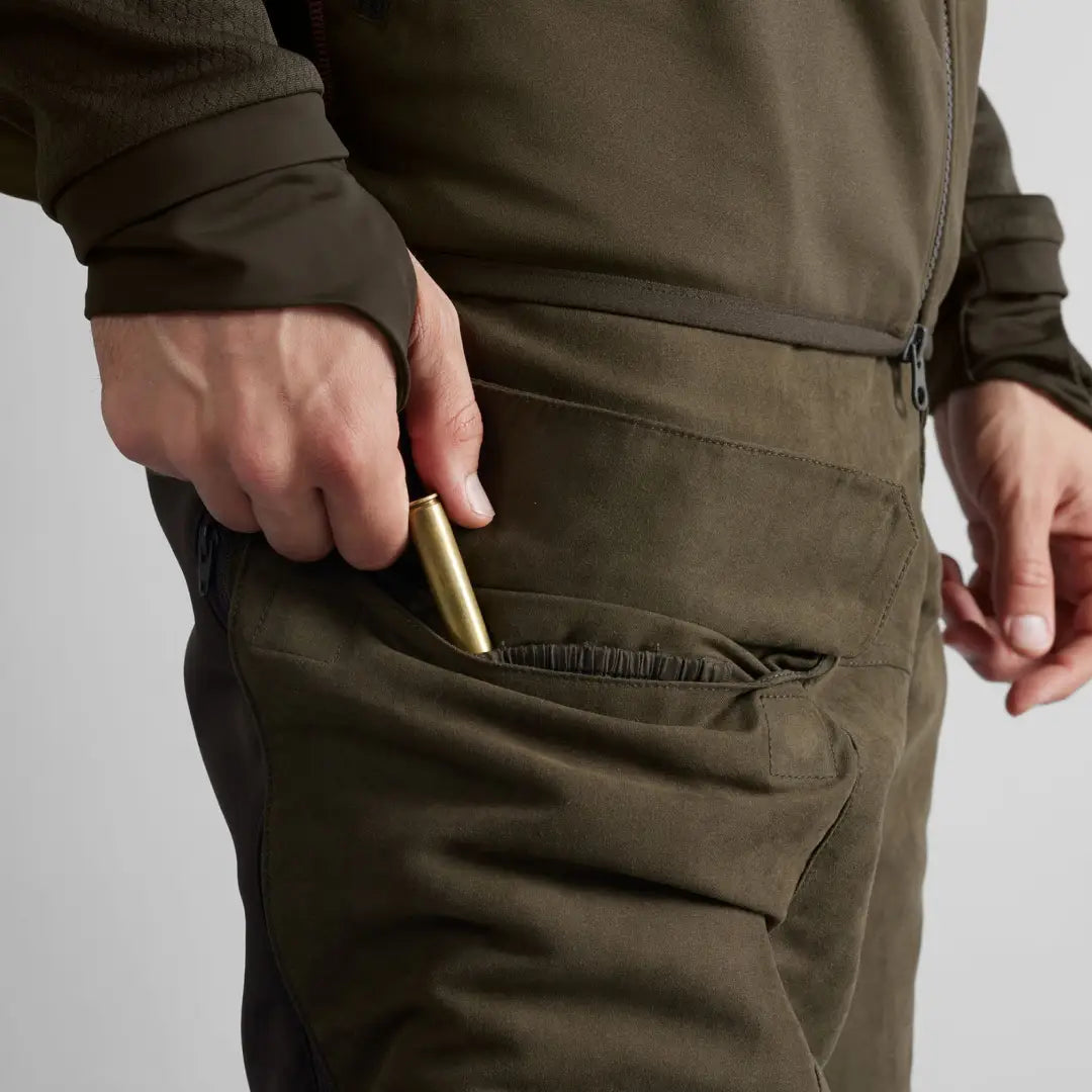 Bullet being inserted into pocket of Härkila Scandinavian Trousers for easy storage