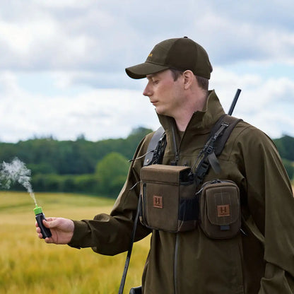 Hunter with smoking wind indicator showcasing Harkila Utility Pouch for country clothing