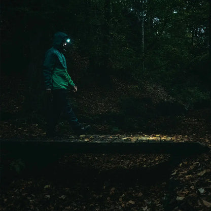 Person exploring dark woods with Highlander Hadar Rechargeable Head Torch