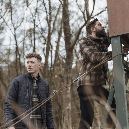 Two men by a hunting blind wearing the Brucefield Fleece Shacket in the woods