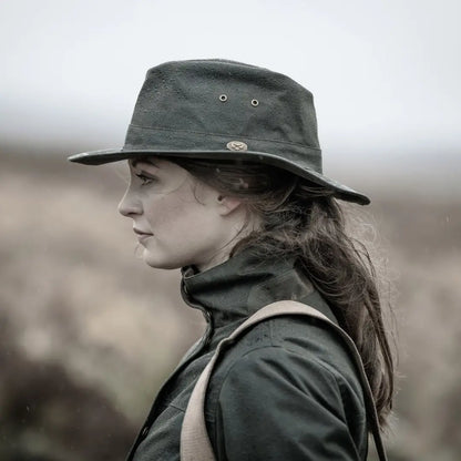 Dark green wide-brimmed hat on a person with long dark hair, Fife Caledonia Waxed style