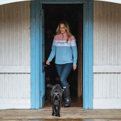 Woman in a colorblock ladies quarter zip sweatshirt walking with a black dog