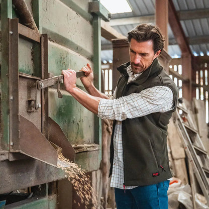 Man operating grain dispenser wearing Hoggs of Fife Green King II Gilet