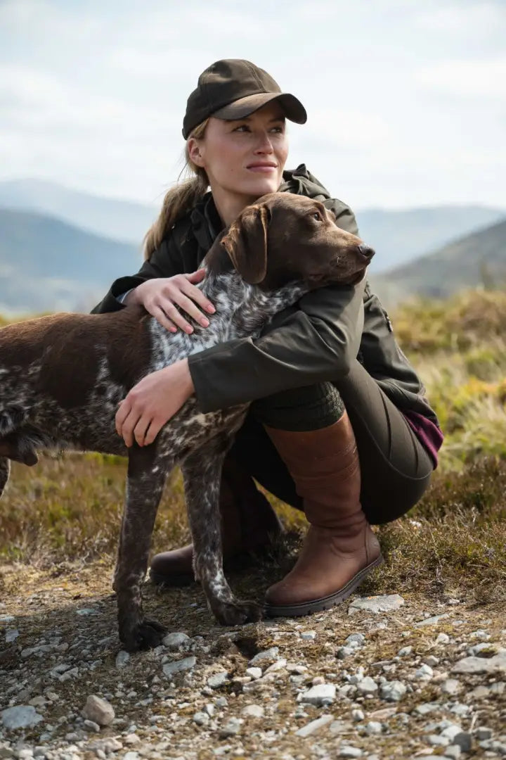 Olive green waterproof jacket with brown leather boots and black cap at Fife Ladies Letham