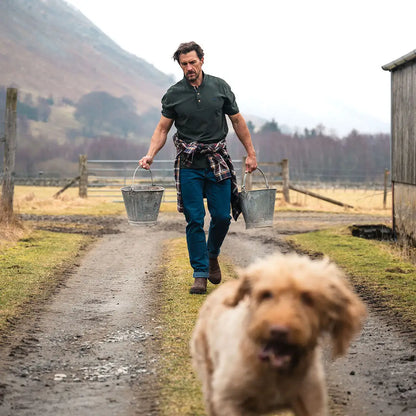 Man in a Hoggs of Fife Newton Pique Polo Shirt carrying buckets outdoors