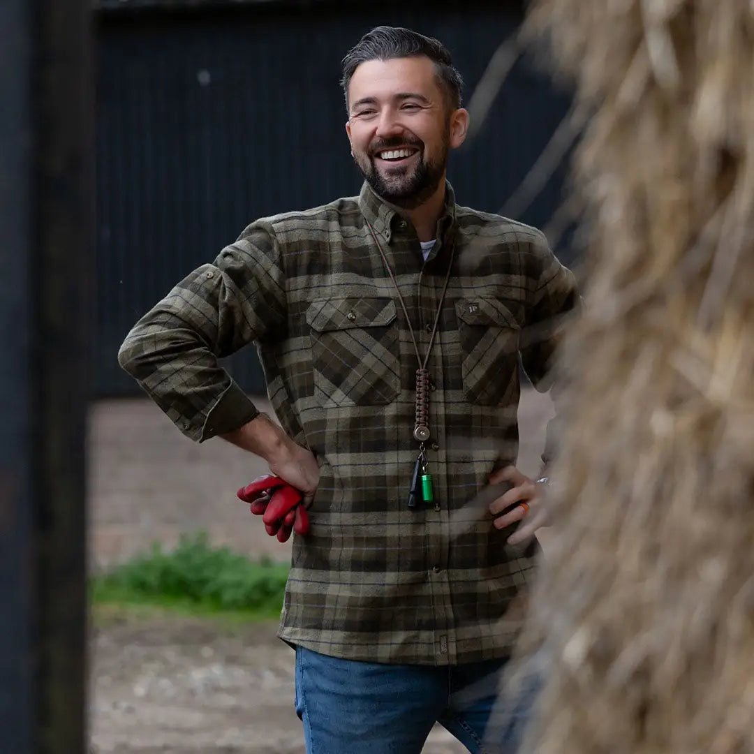 Smiling man wearing a Jack Pyke Bleasdale Heavy Flannel Shirt in plaid style