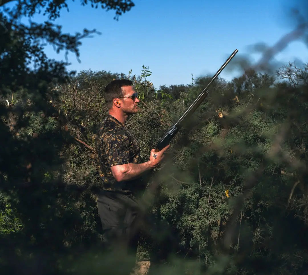 Man holding a shotgun wearing a Jack Pyke Digital Camo T-Shirt outdoors