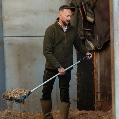 Jack Pyke half zip sherpa fleece pullover in green with black pants and rubber boots