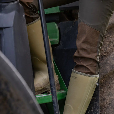 Tan rubber boots paired with brown pants in Jack Pyke Ladies Technical Trousers