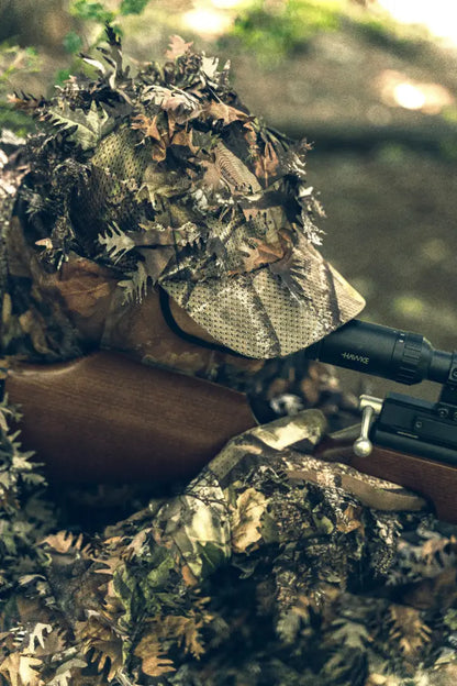 Camouflaged hunter with rifle wearing Jack Pyke LLCS 3D Gloves in the field