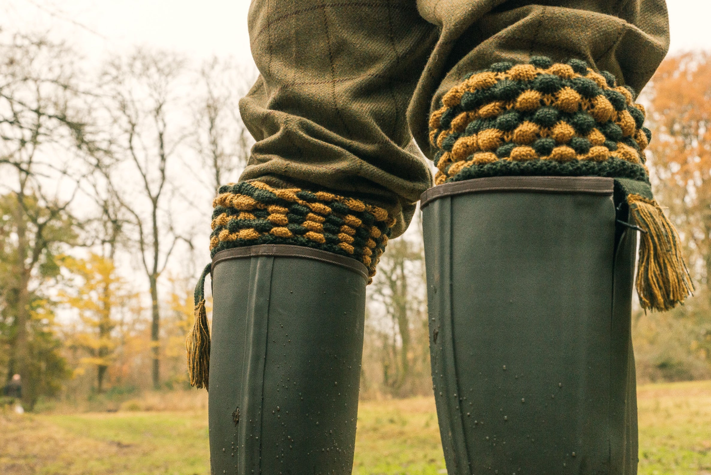 Green rubber boots with cozy knitted cuffs next to Jack Pyke Pebble Shooting Socks