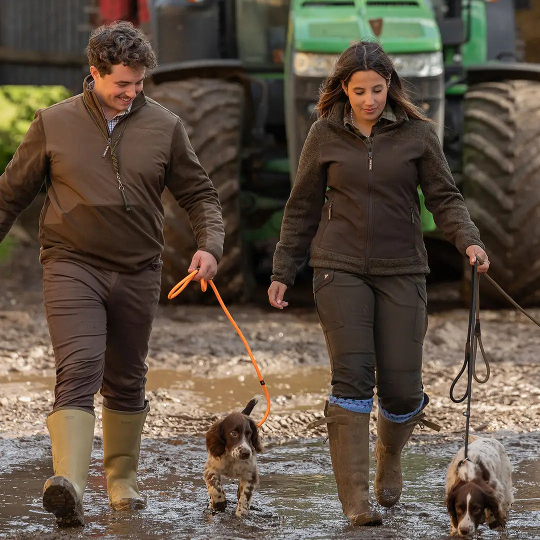Couple in Jack Pyke Rannock Fleece Pullover walking dogs in muddy field