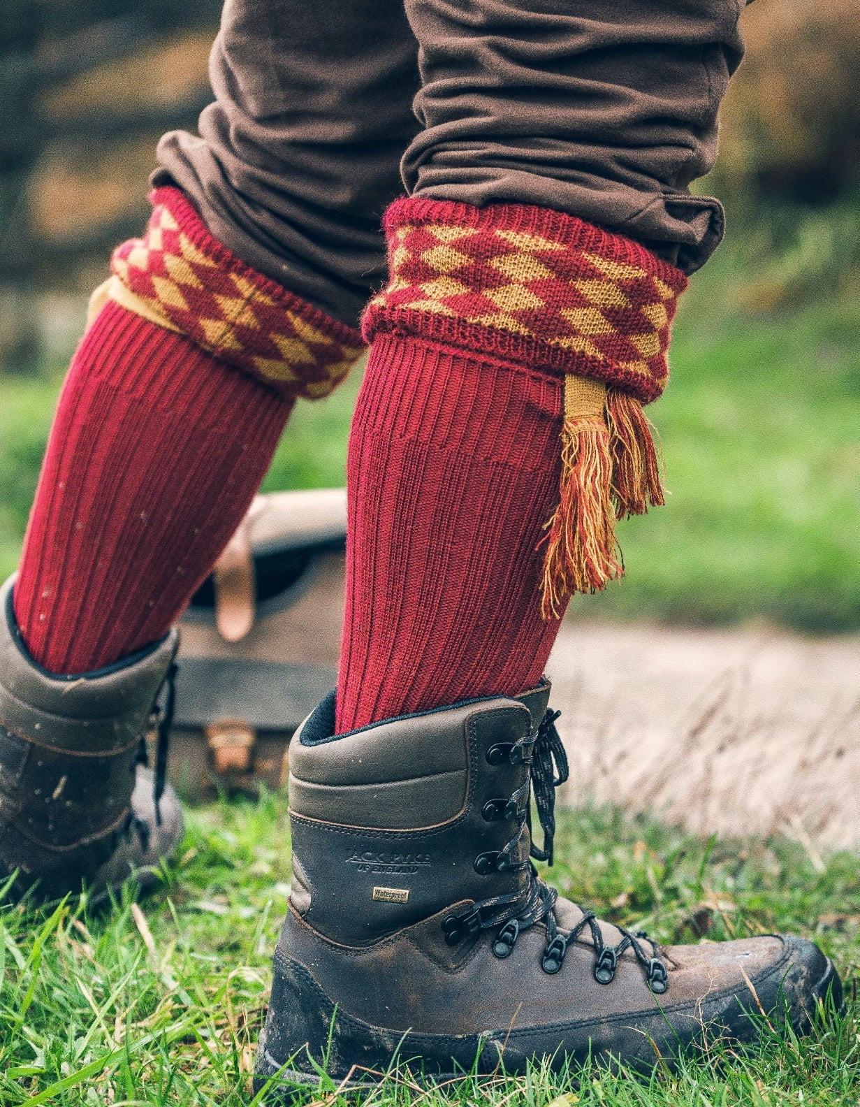 Hiking boots styled with red Jack Pyke Shooting Socks featuring decorative tassels