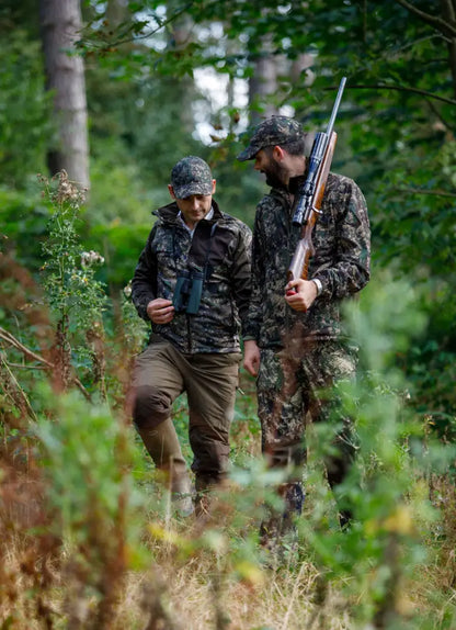 Two hunters in camouflage wearing Jack Pyke Softshell Baseball Caps outdoors