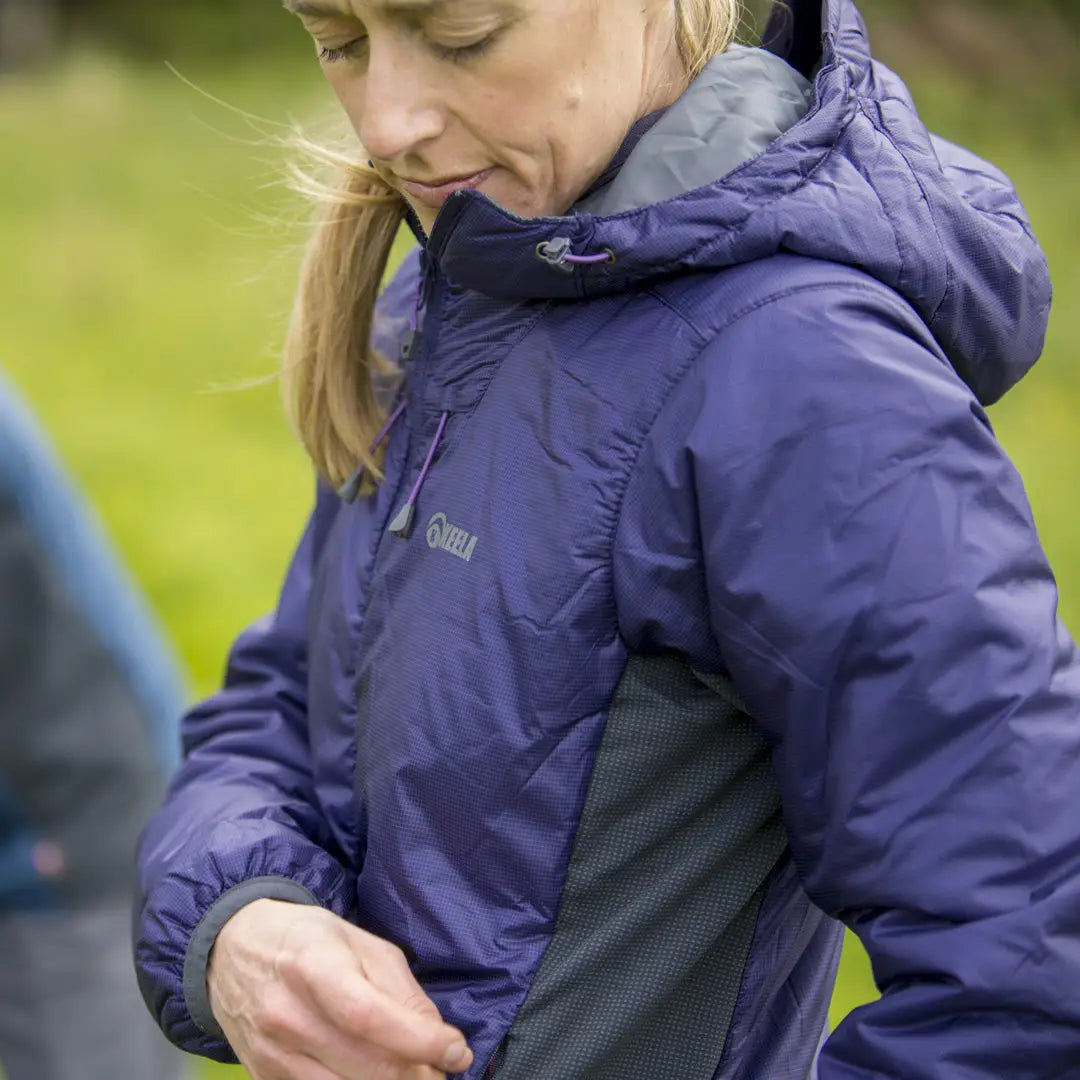 Blonde person wearing a purple Keela Womens Talus Primaloft Jacket with a hood