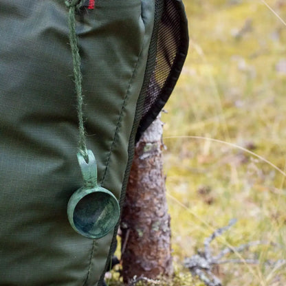 Green backpack with Kupilka Mini Cup hanging from it, perfect for outdoor adventures