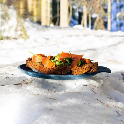 Smoked salmon on dark bread served on a Kupilka Small Plate for outdoor adventures