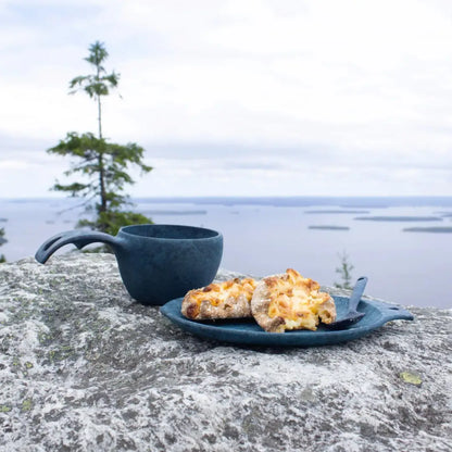 Blue camping cup and pastries on Kupilka Small Plate, perfect for outdoors and country clothing