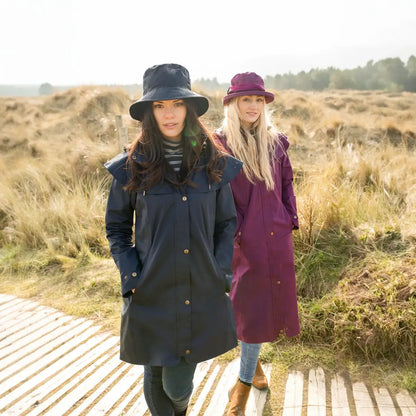 Two women in coats and hats on a walkway, showcasing the Lighthouse Canterbury Waterproof Ladies Hat