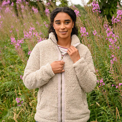 Woman in cream sherpa fleece jacket wearing striped shirt, Lighthouse Cobh zip fleece, country clothing style