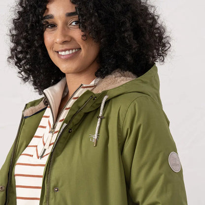 Woman wearing a green Lighthouse Isobel Coat with striped top outdoors