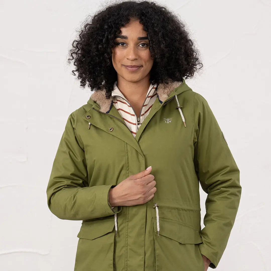 Woman wearing Lighthouse Isobel Coat in olive green insulated parka with fur-lined hood