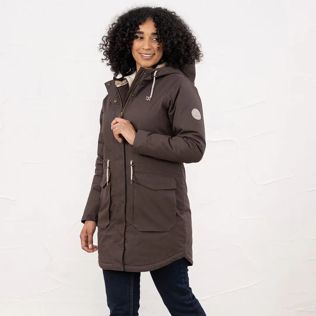 Woman wearing lighthouse isobel coat, long dark brown winter parka with hood and pockets
