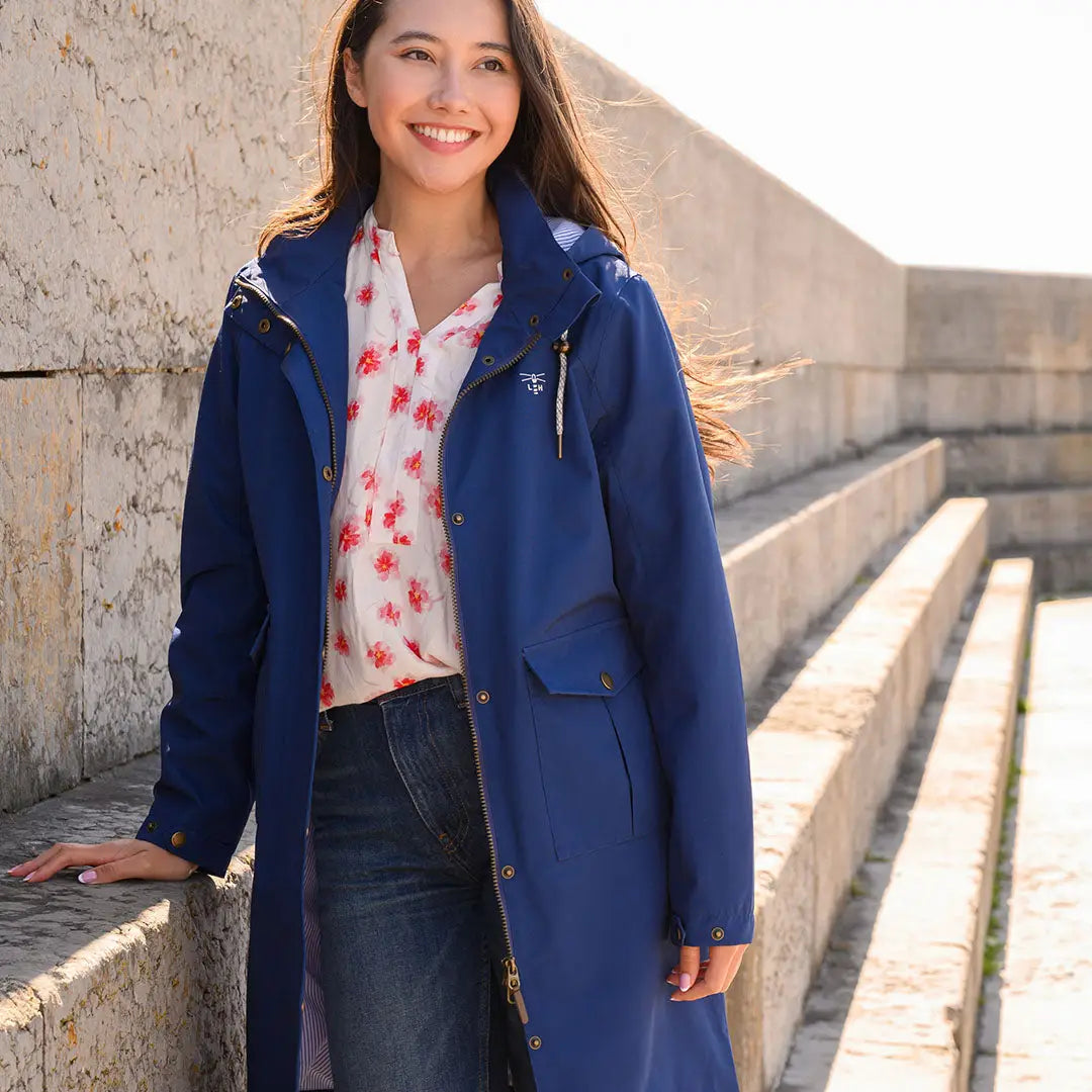 Woman in a blue raincoat wearing the Lighthouse Ladies Annika Coat outdoors