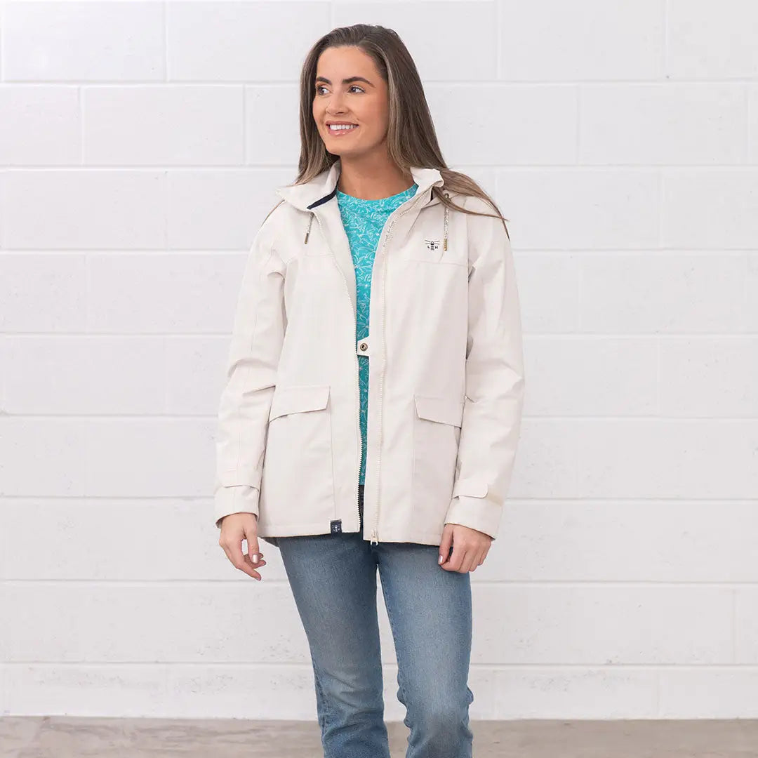 Woman in a beige jacket and jeans wearing the Lighthouse Ladies Beachcomber II Coat