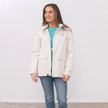Woman in a beige jacket and jeans wearing the Lighthouse Ladies Beachcomber II Coat