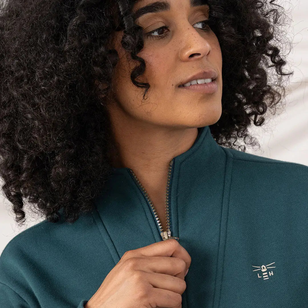 Lighthouse Ladies Coral Jersey featuring a woman in a dark teal jacket with embroidered logo
